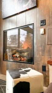 a living room with a fireplace and a stool at Slopeside Chalet in Steamboat Springs