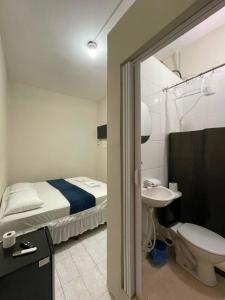 a bathroom with a bed and a sink and a toilet at Pousada Imperatriz in Aparecida +44 photos