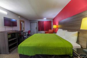 a hotel room with a green bed and a television at The Lodge at the Falls in Wichita Falls +7 photos