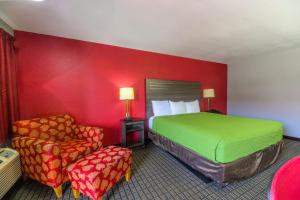 a hotel room with a bed and a chair at The Lodge at the Falls in Wichita Falls
