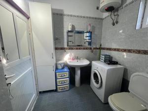 a bathroom with a sink and a washing machine at Villa Victoria in Gjirokastër