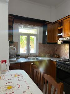 a kitchen with a table and a sink and a window at Villa Victoria in Gjirokastër +15 photos