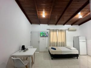 a room with a bed and a table and a tv at Aguara Falls in Puerto Iguazú