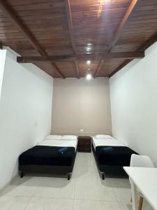 two beds in a room with a wooden ceiling at Aguara Falls in Puerto Iguazú