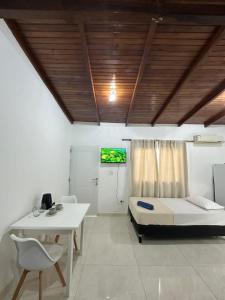 a room with a bed and a table and a tv at Aguara Falls in Puerto Iguazú
