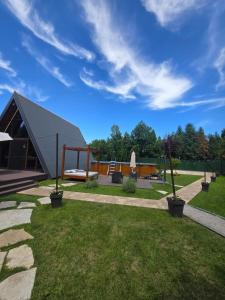 a house with a metal roof on a lawn at Navas River House in Poljane