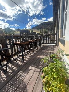 a deck with tables and chairs on a building at Aspen Inn in Creede