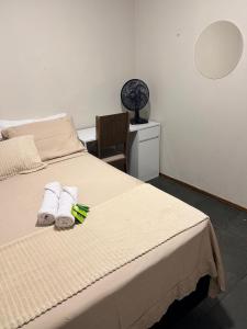 a bedroom with a bed with towels and a chair at Apartamento Prático Completo in Goiânia +14 photos