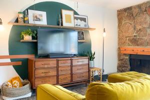a living room with a tv and a dresser with a television at Sunset Sanctuary in Steamboat Springs