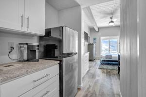 a kitchen with white cabinets and a refrigerator at Gondola Heights Hideaway in Steamboat Springs