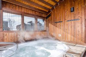 a hot tub in a wooden room with smoke coming out of it at Gondola Heights Hideaway in Steamboat Springs