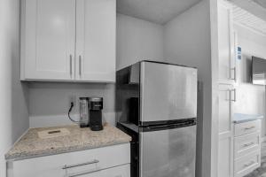 a kitchen with a stainless steel refrigerator and white cabinets at Gondola Heights Hideaway in Steamboat Springs +19 photos