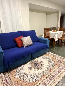 a blue couch sitting in a living room with a rug at Apartamento Prático Completo in Goiânia