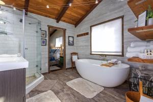 a bathroom with a tub and a shower and a sink at Cabin at the Forest Edge | Hot tub, pet friendly in Packwood
