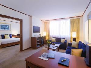 a large living room with a couch and a bed at Novotel Bangkok Bangna in Bangna