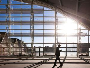 a man walking in front of a large window at Novotel Belfort Centre Atria in Belfort