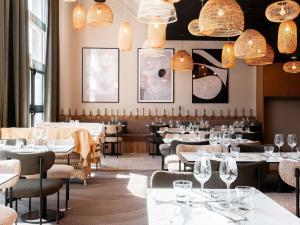 a restaurant with tables and chairs and chandeliers at Novotel Belfort Centre Atria in Belfort