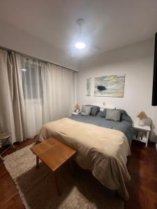 a bedroom with a large bed and a table at Departamento chic centro 2 habitaciones in Mendoza