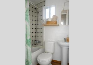 a white bathroom with a toilet and a sink at Refugio Pradera del Sur in Llanquihue +26 photos