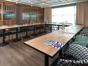 a conference room with long tables and chairs at ibis Styles London Gatwick Airport in Crawley