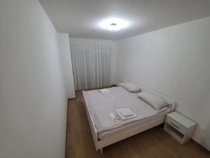 a small white bedroom with a bed in it at Apartman Galić Posušje in Posušje