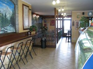 a restaurant with a bar with stools in it at Alice Affittacamere in Cesana Torinese