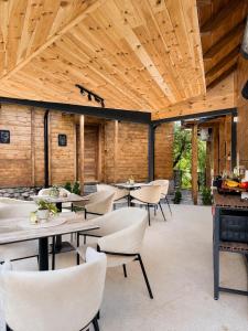 a dining room with tables and chairs and wooden ceilings at 4 Chalets in Kolašin