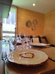 a plate on a table with wine glasses on it at L'Esprit Boisé in Ustou +20 photos
