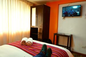a person laying on a bed in a hotel room at Hotel Margarita in Puno