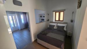 a small bedroom with a bed and a window at Duchess Harbour View in Symi