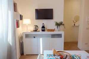 a living room with a table with a tv on a wall at Vicolo 25 in Cinisi +70 photos