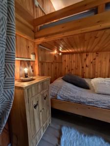 a bedroom with a bed in a wooden cabin at L'Esprit Boisé in Ustou