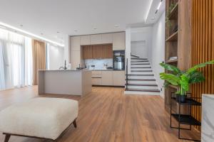 a living room with a kitchen and a stairway at Aria Luxury Villa 2 in Dhërmi