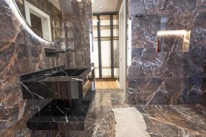 a bathroom with a black marble wall at Aria Luxury Villa 2 in Dhërmi +36 photos