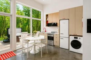 a kitchen with a table and a white refrigerator at The Lofti in Sainte Béatrix