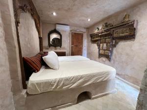 a bedroom with a large bed in a stone room at Tenasbook Jnen Rayhane in Midoun +38 photos
