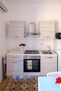 a kitchen with a stove and a sink at Vicolo 25 in Cinisi