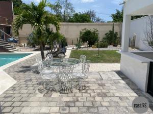 a patio with a glass table and chairs next to a pool at Casa RE Completa in Tehuacán
