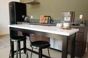 a kitchen with a large white counter and two stools at Frontcountry Salida in Salida