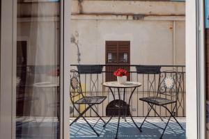 a table and chairs sitting on a balcony at Vicolo 25 in Cinisi