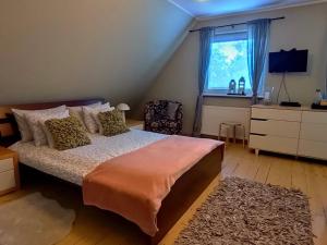 a bedroom with a bed and a dresser and a window at Cherry Tree Cozy Rooms in Gdańsk
