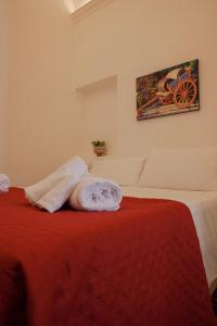 a bedroom with a bed with a red blanket at Vicolo 25 in Cinisi