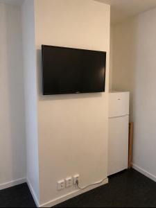 ein Flachbildfernseher, der an einer Wand hängt in der Unterkunft Centrumrooms in Mosjøen