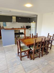 a kitchen with a wooden table and wooden chairs at Quincho Monoambiente Con Parrilla in Balcarce +2 photos