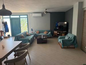 a living room with blue couches and a television at Angela Apartments in Igoumenitsa