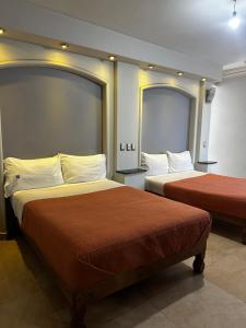 a hotel room with two beds and two mirrors at Hotel kristal in La Barca