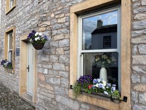 a window with a bunch of flowers in it at Cobble Cottage in Clitheroe