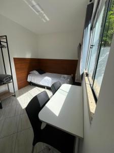 a small room with a desk and a bed at Vaccani Apart in Macaé