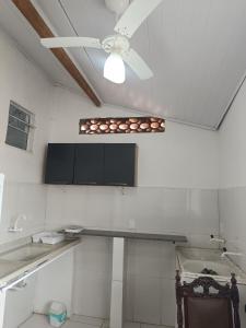 a kitchen with a ceiling fan and a counter at Casa inteira 4 pessoas, 2 quartos, suite ar, 2 banheiros, home office, estacionamento, próx praia Itaúna in Saquarema