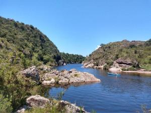 a river with two boats in the middle of a mountain at Chalet del Rio in Cuesta Blanca +14 photos